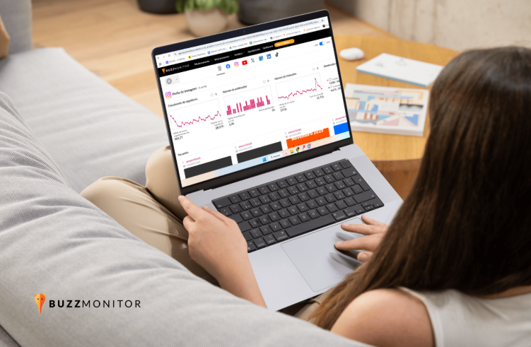 Mulher com computador no colo, com interface da Buzzmonitor, ferramenta de social analytics