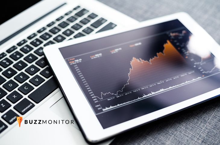 Tablet sobre notebook exibe gráfico financeiro com tendência de crescimento ao longo de um ano.