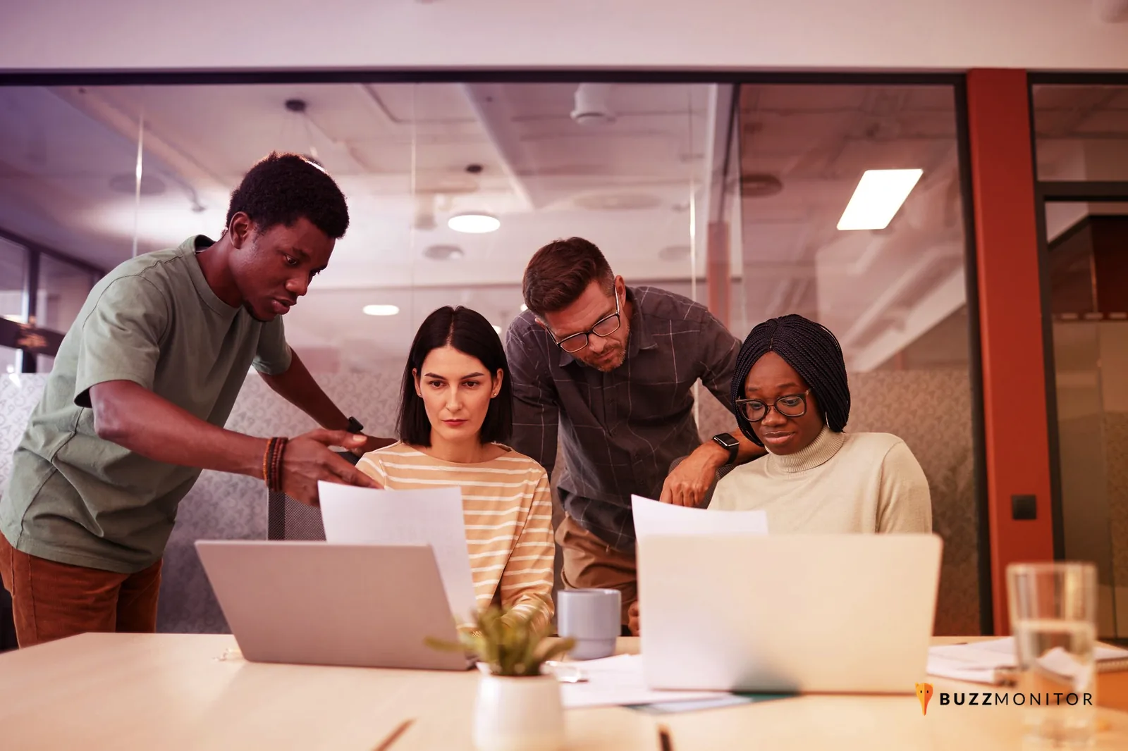 Equipa a analisar um dashboard de apoio ao cliente numa sala de trabalho